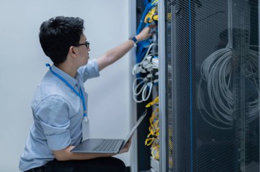 Bilgisayar mühendisi sunucu odasında ağ kuruyor, Sistem Bakım teknisyeni, erkek mühendis modern veri merkezinde sunucu odasında çalışıyor.