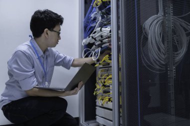 Bilgisayar mühendisi sunucu odasında ağ kuruyor, Sistem Bakım teknisyeni, erkek mühendis modern veri merkezinde sunucu odasında çalışıyor.