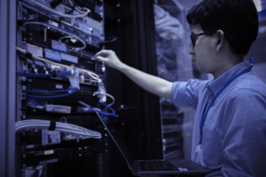 Bilgisayar mühendisi sunucu odasında ağ kuruyor, Sistem Bakım teknisyeni, erkek mühendis modern veri merkezinde sunucu odasında çalışıyor.