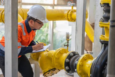 Petrol rafinerisi bölgesinde çalışan Petrokimya mühendisi. Endüstriyel teknisyen bakım, fabrikadaki enerji enerji gaz sistemini denetliyor.. 