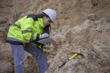 Benimkini inceleyen jeolog, kaşifler mineralleri aramak, dünyanın derinliklerini araştırmak, kaya oluşumlarını analiz etmek için toprak örnekleri topluyor.