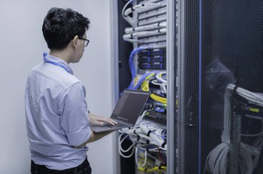 Bilgisayar mühendisi sunucu odasında ağ kuruyor, Sistem Bakım teknisyeni, erkek mühendis modern veri merkezinde sunucu odasında çalışıyor.