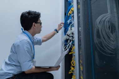 Bilgisayar mühendisi sunucu odasında ağ kuruyor, Sistem Bakım teknisyeni, erkek mühendis modern veri merkezinde sunucu odasında çalışıyor.