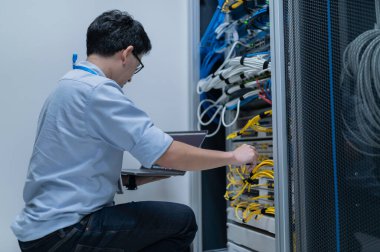 Bilgisayar mühendisi sunucu odasında ağ kuruyor, Sistem Bakım teknisyeni, erkek mühendis modern veri merkezinde sunucu odasında çalışıyor.