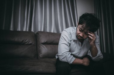 Asyalı yakışıklı adam aşırı iş yükünden dolayı stresli. Yorgun erkek, şirketten bir sürü iş ve depresyon riskinden sonra eve döner..