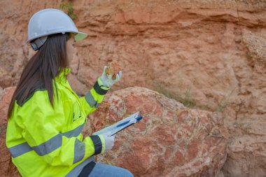 Benimkini inceleyen jeolog, kaşifler mineralleri aramak, dünyanın derinliklerini araştırmak, kaya oluşumlarını analiz etmek için toprak örnekleri topluyor.
