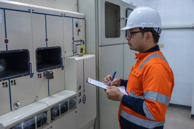 Elektrik mühendisleri ve teknisyenleri endüstriyel kontrol odalarındaki elektrik sistemi arızalarını çözmek için birlikte çalışıyorlar..