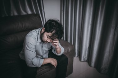 Asyalı yakışıklı adam aşırı iş yükünden dolayı stresli. Yorgun erkek, şirketten bir sürü iş ve depresyon riskinden sonra eve döner..