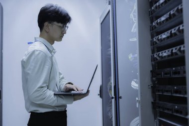 Bilgisayar mühendisi sunucu odasında ağ kuruyor, Sistem Bakım teknisyeni, erkek mühendis modern veri merkezinde sunucu odasında çalışıyor.