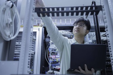 Bilgisayar mühendisi sunucu odasında ağ kuruyor, Sistem Bakım teknisyeni, erkek mühendis modern veri merkezinde sunucu odasında çalışıyor.