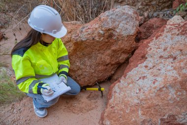 Benimkini inceleyen jeolog, kaşifler mineralleri aramak, dünyanın derinliklerini araştırmak, kaya oluşumlarını analiz etmek için toprak örnekleri topluyor.