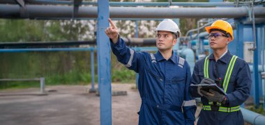 Petrol rafinerisi bölgesinde çalışan Petrokimya mühendisleri. Endüstriyel teknisyenler, fabrikadaki enerji enerji gaz sistemini denetliyor..