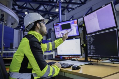 Kontrol odasında çalışan bir mühendis, yönetici kontrol sistemi. Birçok monitörden teknisyen izleme programı.