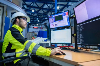 Kontrol odasında çalışan bir mühendis, yönetici kontrol sistemi. Birçok monitörden teknisyen izleme programı.