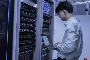 Bilgisayar mühendisi sunucu odasında ağ kuruyor, Sistem Bakım teknisyeni, erkek mühendis modern veri merkezinde sunucu odasında çalışıyor.