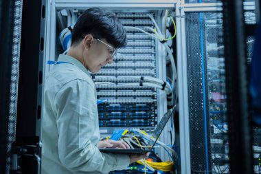 Bilgisayar mühendisi sunucu odasında ağ kuruyor, Sistem Bakım teknisyeni, erkek mühendis modern veri merkezinde sunucu odasında çalışıyor.