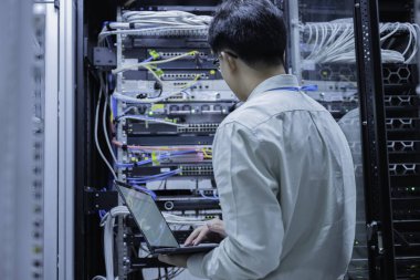 Bilgisayar mühendisi sunucu odasında ağ kuruyor, Sistem Bakım teknisyeni, erkek mühendis modern veri merkezinde sunucu odasında çalışıyor.