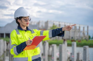 Tayland 'da büyük bir inşaat projesinin şantiyesinde çalışan Asyalı mühendis inşaat alanında fazla mesai yapıyor. 