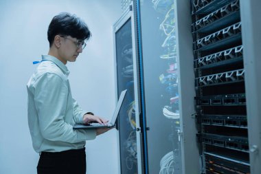 Bilgisayar mühendisi sunucu odasında ağ kuruyor, Sistem Bakım teknisyeni, erkek mühendis modern veri merkezinde sunucu odasında çalışıyor.