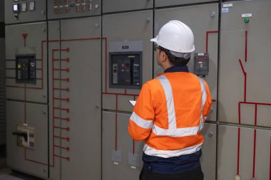 Elektrik mühendisleri ve teknisyenleri endüstriyel kontrol odalarındaki elektrik sistemi arızalarını çözmek için birlikte çalışıyorlar..