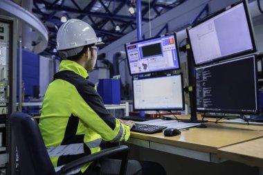 Kontrol odasında çalışan bir mühendis, yönetici kontrol sistemi. Birçok monitörden teknisyen izleme programı.