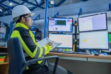 Kontrol odasında çalışan bir mühendis, yönetici kontrol sistemi. Birçok monitörden teknisyen izleme programı.