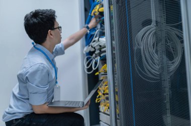 Bilgisayar mühendisi sunucu odasında ağ kuruyor, Sistem Bakım teknisyeni, erkek mühendis modern veri merkezinde sunucu odasında çalışıyor.