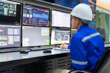 Kontrol odasında çalışan mühendis, yönetici kontrol sistemi, birçok monitörden teknisyen izleme programı.