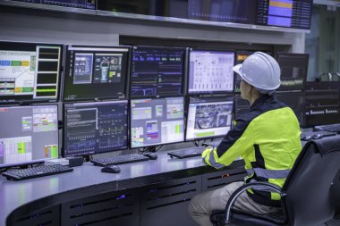 Kontrol odasında çalışan mühendis, yönetici kontrol sistemi, birçok monitörden teknisyen izleme programı.