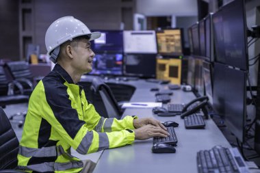 Kontrol odasında çalışan mühendis, yönetici kontrol sistemi, birçok monitörden teknisyen izleme programı.
