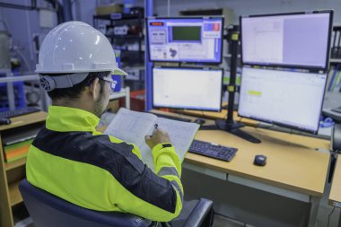 Kontrol odasında çalışan bir mühendis, yönetici kontrol sistemi. Birçok monitörden teknisyen izleme programı.