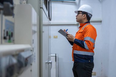 Elektrik mühendisleri ve teknisyenleri endüstriyel kontrol odalarındaki elektrik sistemi arızalarını çözmek için birlikte çalışıyorlar..