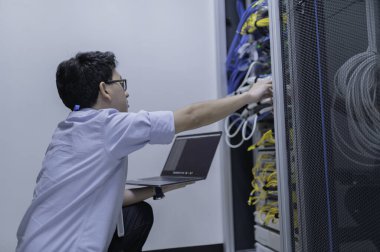 Bilgisayar mühendisi sunucu odasında ağ kuruyor, Sistem Bakım teknisyeni, erkek mühendis modern veri merkezinde sunucu odasında çalışıyor.