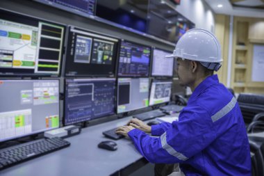 Kontrol odasında çalışan mühendis, yönetici kontrol sistemi, birçok monitörden teknisyen izleme programı.