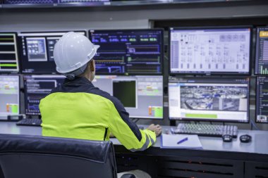 Kontrol odasında çalışan mühendis, yönetici kontrol sistemi, birçok monitörden teknisyen izleme programı.