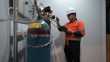 Erkek Asyalı Mühendis Oksijen Borularını Denetliyor, Sıvı Helyum Soğutma Sistemini Korumakta, Eşya Güvenliğini Sağlama, Basınç Kontrolü, Çelik Tank Güvenlik Sistemlerini İzleme