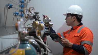 Erkek Asyalı Mühendis Oksijen Borularını Denetliyor, Sıvı Helyum Soğutma Sistemini Korumakta, Eşya Güvenliğini Sağlama, Basınç Kontrolü, Çelik Tank Güvenlik Sistemlerini İzleme