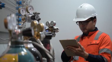 Erkek Asyalı Mühendis Oksijen Borularını Denetliyor, Sıvı Helyum Soğutma Sistemini Korumakta, Eşya Güvenliğini Sağlama, Basınç Kontrolü, Çelik Tank Güvenlik Sistemlerini İzleme