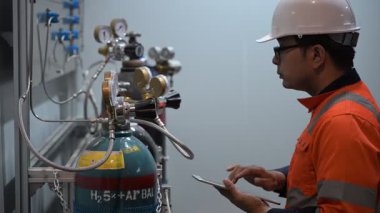 Erkek Asyalı Mühendis Oksijen Borularını Denetliyor, Sıvı Helyum Soğutma Sistemini Korumakta, Eşya Güvenliğini Sağlama, Basınç Kontrolü, Çelik Tank Güvenlik Sistemlerini İzleme