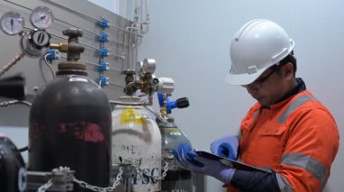 Erkek Asyalı Mühendis Oksijen Borularını Denetliyor, Sıvı Helyum Soğutma Sistemini Korumakta, Eşya Güvenliğini Sağlama, Basınç Kontrolü, Çelik Tank Güvenlik Sistemlerini İzleme