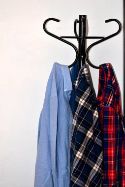 kırmızı ve mavi ekose gömlekler ve demirci rafında sade gömlek