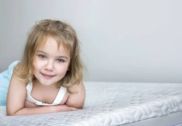 マットレスの上の子供の女の子空のスペースの背景 ベッドの肖像画の子供 — ストック写真