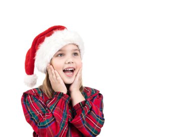 Küçük kız Noel Baba 'nın şapkasıyla şaşırdı. Noel kostümü giymiş çocuk heyecanlandı. Mutlu çocuk. Yeni yıl konsepti..