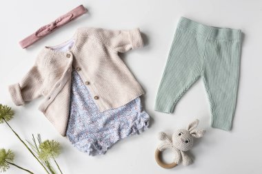 Beyaz arka planda bebek kıyafetleri. Örgü çocuk kıyafeti. Konforlu organik giysi. Güzel bebek kıyafeti..