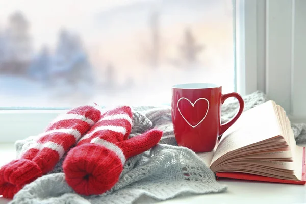 Cup of tee coffee and book on windowsill. Christmas comfort. Cold weather. Reading concept. Winter mood.. Valentines day empty spae background.