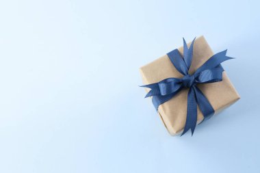 Mavi kurdeleli mevcut kutu ve boş uzay mavi arkaplan üzerinde yay üst görünümü. Babalar günü hediyesi. Tatil paketi.