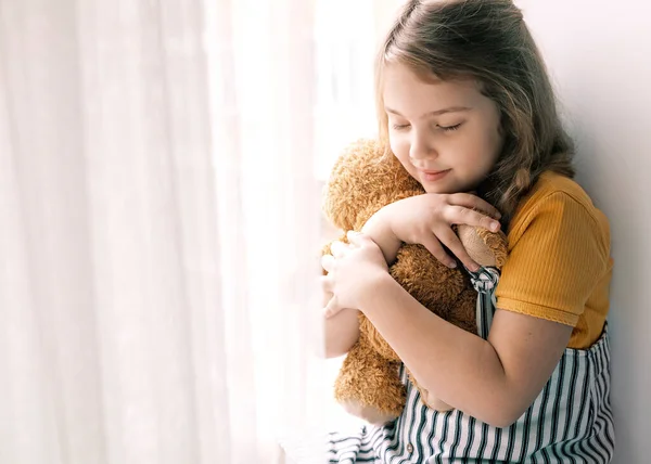 Güzel beyaz kız oyuncak ayı tutuyor, oyuncaklı çocuk, gülümseyen mutlu çocuk portresi. Mutlu çocukluk. Aşk konsepti. İlişki ve arkadaşlık.