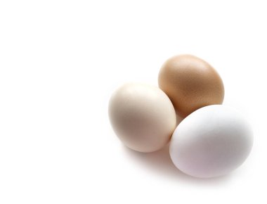 Üç yumurta beyaza boyanmış. Tavuk çiftliği yumurtalarından oluşan farklı renkte bir grup..