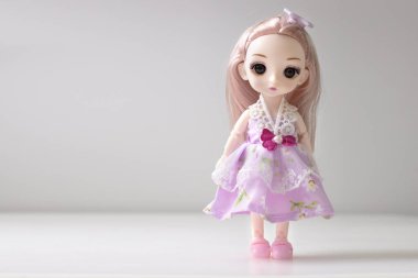 Beyaz Emty Space arka planında duran tek bir bebek. Oyuncak kız. İnsan..