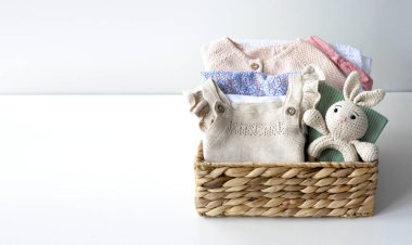 Bebek kıyafetleri sepette boş fotokopi odasında katlanmış yeni doğan kıyafetleri ve oyuncaklar, küçük çocuklar, renkli kadın giysileri.